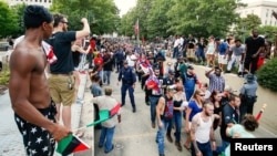 Protesters yell at members of the Ku Klux Klan as they march after leaving a rally at the South Carolina State House in Columbia, July 18, 2015. 