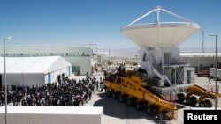 Workers and visitors gather around a vehicle loading a parabolic antenna during the Atacama Large Millimetre/Submillimetre Array (ALMA) observatory inauguration, east of Calama, Chile, Mar. 13, 2013.