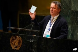 Ukrainian Ambassador to the United Nations Sergiy Kyslytsya holds up a copy of the charter of the United Nations while speaking during an emergency meeting of the General Assembly at United Nations headquarters, March 2, 2022.