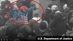 Robert Scott Palmer throws a fire extinguisher during the Jan. 6, 2021, breach of the Capitol in this image from the US Department of Justice and enhanced to highlight Palmer.