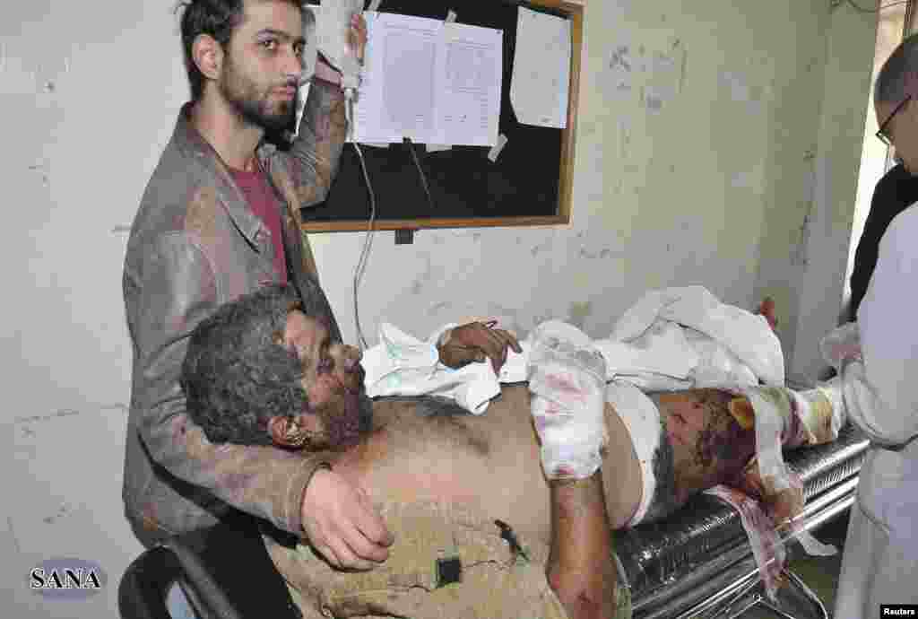 A man wounded in the explosions in Jaramana district, near Damascus, receives treatment at a hospital, in this handout photograph released by Syria's national news agency SANA, November 28, 2012. 