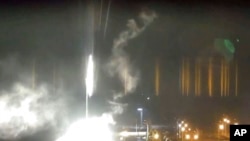 This image made from a video released by Zaporizhzhia nuclear power plant shows a bright flaring object landing in grounds of the nuclear plant in Enerhodar, Ukraine, March 4, 2022. 
