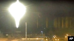 This image made from a video released by the Zaporizhzhia Nuclear Power Plant shows a bright flaring object landing on the grounds of the nuclear plant in Enerhodar, Ukraine, March 4, 2022. 