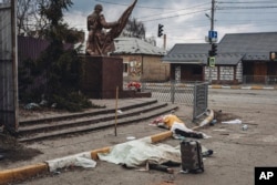 The dead bodies of people killed by Russian shelling lay covered in the street in the town of Irpin, Ukraine, March 6, 2022.