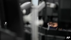 A currency trader watches computer monitors at a foreign exchange dealing room in Seoul, South Korea, Monday, March 7, 2022. The price of oil jumped more than $10 a barrel and shares were sharply lower Monday as the conflict in Ukraine deepened amid mounting calls for harsher sanctions against Russia. (AP Photo/Lee Jin-man)