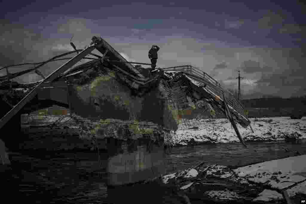 A man stands atop a destroyed bridge in Irpin, March 8, 2022.