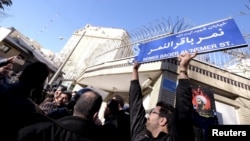 Warga Iran melakukan protes atas eksekusi terhadap ulama Syiah Nimr Al-Nimr di depan Kedutaan Arab Saudi di Teheran, Minggu (3/1).