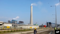 Men work near the Maitree Super Thermal Power Project near the Sundarbans, the world’s largest mangrove forest, in Rampal, Bangladesh, Monday, Oct. 17, 2022.