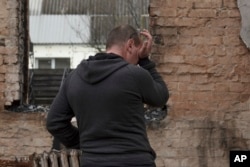Vadym Zherdetsky reacts standing in the remains of his destroyed house, in the village of Moshun, outside Kyiv, Ukraine, Friday, Nov. 4, 2022.