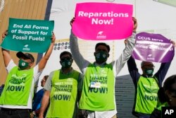 A group of demonstrators participate in an event protesting the use of fossil fuels and calling for reparations at the COP27 U.N. Climate Summit, in Sharm el-Sheikh, Egypt, Nov. 9, 2022.