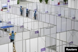FILE - Workers set up equipment inside Pazhou International Convention Exhibition Center to convert it into a makeshift hospital for the coronavirus disease (COVID-19), in Guangzhou, Guangdong province, China April 10, 2022. (cnsphoto via Reuters)