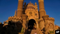 A woman poses for a picture on the stairs of the Al Sahaba mosque in in Sharm el-Sheikh, Egypt, Nov. 5, 2022. 