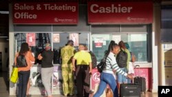 People queue at the Kenya Airways ticket office in Jomo Kenyatta International Airport in Nairobi, Kenya, on Monday during a strike by pilots working for Kenya's national airline Kenya Airways. Flights resumed Wednesday after a court order ended the strike.