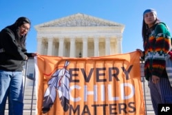Native American demonstrators stand outside of the U.S. Supreme Court, as the court hears arguments over the Indian Child Welfare Act, Wednesday, Nov. 9, 2022, in Washington.
