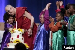 A group of children celebrate with the Dalai Lama after he blew out a candle on his birthday cake at the University of California, Irvine on July 6, 2015.