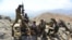 FILE - Afghan resistance movement and anti-Taliban forces take a break as they patrol on a hilltop in the Darband area of Anaba district, in Afghanistan's Panjshir province, Sept. 1, 2021.