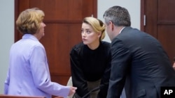 L'actrice Amber Heard s'entretient avec ses avocats dans la salle d'audience du palais de justice à Fairfax, en Virginie, le 25 avril 2022.