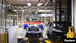 上汽集团在临港的汽车生产基地里，工人在生产线上工作。（2022年4月23日）