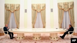 Russian President Vladimir Putin, left, keeps his distance while meeting with U.N. Secretary-General Antonio Guterres in the Kremlin, in Moscow, Russia, April 26, 2022.