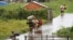 FILE - Residents wade through flood water around their homes after heavy rain in Antananarivo, Madagascar, Jan. 19, 2022. 