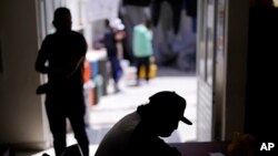 FILE - A Nicaraguan man sits in a migrant shelter in Tijuana, Mexico, April 21, 2022. He is waiting in Mexico for hearings in U.S. immigration court.