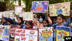 Students hold placards during an event to mark the World Malaria Day at a government hospital on the outskirts of Amritsar in India on April 25, 2022. 