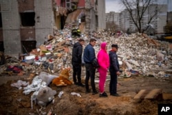 Residents look at their house destroyed by a Russian bomb in Chernihiv, April 22, 2022.