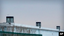 FILE - A person stands in a tower on the perimeter of the No. 3 Detention Center in Dabancheng in western China's Xinjiang Uyghur Autonomous Region, April 23, 2021. 