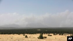 Plumes of smoke rise from a pair of growing wildfires in northeast New Mexico, outside Las Vegas, April 22, 2022. Southwest fires have burned dozens of homes in northern Arizona and put numerous small villages in New Mexico in the path of danger.