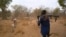FILE - An armed cattle keeper walks with his cows during a seasonal migration of cattle for grazing near Tonj, South Sudan, Feb. 16, 2020.