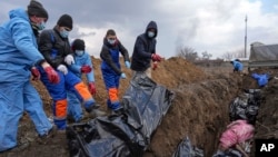 Dead bodies are placed into a mass grave on the outskirts of Mariupol, Ukraine, March 9, 2022 as people cannot bury their dead because of the heavy shelling by Russian forces.