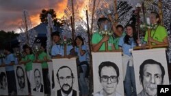 Estudiantes de la Universidad Centroamericana José Simeón Cañas sostienen retratos de los seis sacerdotes jesuitas de España asesinados por el ejército salvadoreño durante la guerra civil en 1989, mientras participan en una ceremonia de homenaje. [Foto de archivo]