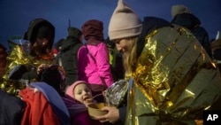 ស្ត្រី​ម្នាក់​បញ្ចុក​ម្ហូប​ដល់​កូនស្រី​របស់​គាត់​ ក្រោយ​ពី​រត់ភៀសខ្លួន​ចេញ​ពី​អ៊ុយក្រែន មក​ដល់​ប្រទេស​ប៉ូឡូញ ថ្ងៃទី៧ ខែមីនា​ ឆ្នាំ២០២២។ (AP Photo/Visar Kryeziu)