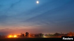 FILE - The illuminated fenced border between India and Pakistan is pictured at a village in Ranbir Singh Pura sector near Jammu, March 1, 2019. 
