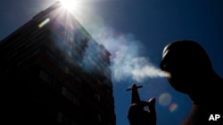 FILE - In this Jan. 18, 2012 photo, a smoker puffs on a cigarette in the central business district in Auckland, New Zealand.