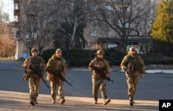 Ukrainian soldiers walk along a street in the area of the heaviest battles with the Russian invaders in Bakhmut, Ukraine, Dec. 20, 2022.