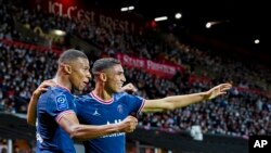 Punggawa Paris Saint-Germain Kylian Mbappe (kiri) merayakan keberhasilannya mencetak gol dengan rekan satu timnya Achraf Hakimi dalam pertandingan Liga Satu Prancis di Stadion Francis-Le Ble di Brest, Prancis, pada 20 Agustus 2021. (Foto: AP/Daniel Cole)