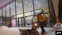 A person uses a snow blower to clear a sidewalk outside of Union Station in Chicago, Dec. 22, 2022, during a winter storm ahead of the Christmas holiday.