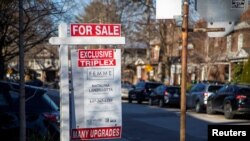 FILE - A realtor's "for sale" sign is posted outside a home in Toronto, Canada, Dec. 13, 2021. 
