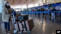 A masked traveler arrives at the international flight check-in counter at the Beijing Capital International Airport in Beijing, Dec. 29, 2022. 