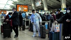 A passenger wearing protective gear is seen at a train station in Beijing on Dec. 28, 2022. 