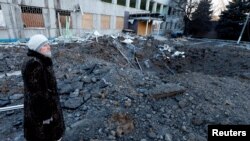Seorang perempuan melihat lokasi serangan rudal yang terjadi pada malam hari, di tengah serangan Rusia terhadap Ukraina, di Kramatorsk, Ukraina, 8 Januari 2023. (Foto: REUTERS/Clodagh Kilcoyne)