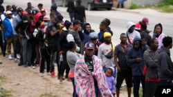 Haitians seeking asylum in the U.S. gather along the U.S.-Mexico border as they wait to register with a religious organization, in Reynosa, Mexico, Dec. 21, 2022.