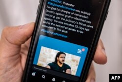 FILE - A person in the Cypriot capital, Nicosia, checks a mobile phone on Dec. 12, 2022, displaying a tweet about the execution announced by Iranian authorities of Majidreza Rahnavard, the second capital punishment linked to nearly three months of protests.