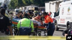 A subway passenger injured when two subway trains collided is taken on a stretcher to an ambulance in Mexico City, Jan. 7, 2023.