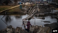 A woman crosses a destroyed bridge in Bakhmut, Donetsk region, Jan. 6, 2023.