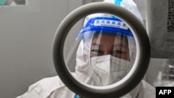 A health worker waits for people to take swab samples to test for COVID-19 in the Jing'an district in Shanghai on Dec. 23, 2022.