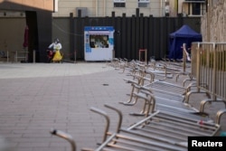 身穿防护服的工作人员在等候上海市民前来做新冠核酸检测。（2022年12月22日）