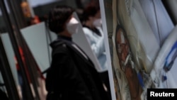 FILE - A photo of Yao Pan Ma in critical condition at a hospital, after being assaulted April 23, 2021, in the Harlem neighborhood of Manhattan, stands during a press conference in New York City, April 27, 2021.