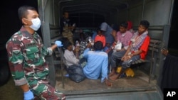 Ethnic Rohingya refugees sit at the back of a military truck after their boat landed in Pidie, Aceh province, Indonesia, Dec. 26, 2022.